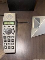 Handset on charging stand showing display and keypad