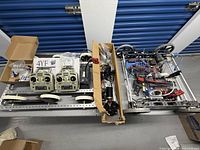 Overview of entire lot on table including radios, wheels, chassis, wiring