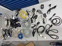 Overview of entire lot showing controllers, power strip, numerous cables and adapters
