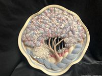 Front view of ceramic wall plate showing entire woven yarn tree artwork