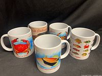 Five ceramic mugs displaying various Hawaiian sea life designs