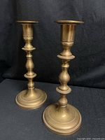 Front view of both brass candlesticks showing overall form and finish