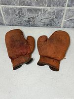 Pair of brown leather children boxing gloves, palms down