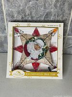 Front view of boxed tree topper showing star design, Lucy image and branding