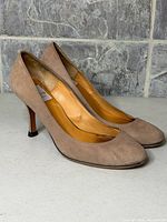 Full side view of both pumps showing suede exterior and heel