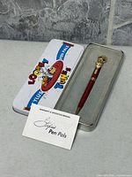 Pen, tin case and manual displayed together