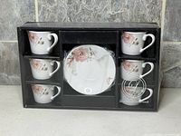 Front view of boxed cup and saucer set showing six cups and one saucer through plastic window