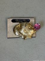 Front view of brooch on card showing design details