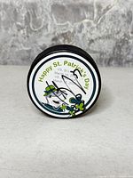 Front of puck showing St. Patrick's Day design and Curtis Brown autograph