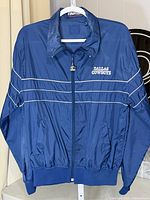 Front view of blue Dallas Cowboys zip jacket on hanger