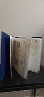 Blue binder open showing plastic sleeves of Soviet envelopes/postcards