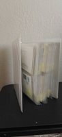 Binder standing on edge showing filled plastic sleeves of envelopes