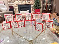 All 13 BallQube baseball holders on glass table, showing boxed units and one unboxed cube