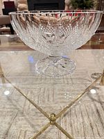 Full view of footed crystal bowl on glass table