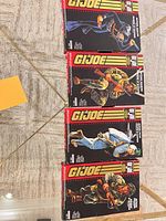 Four GI Joe Commemorative Collection boxes laid out