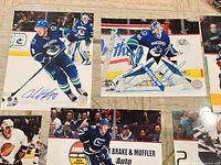 Two signed 8x10 photos: #8 skater and goaltender in blue jerseys with visible signatures