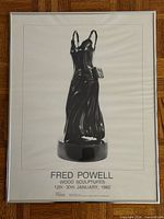 Full view of framed poster showing sculpture and text