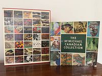 Front view showing both hardcover art books with illustrated dust jackets