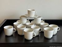 Pyramid arrangement of 12 cups with stacked saucers, overall view