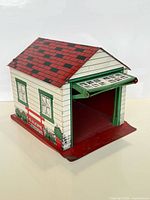 Front and side view of tin toy garage showing working door and printed graphics