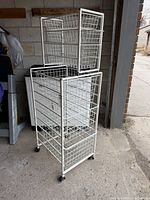Front view of white metal rolling shelving with baskets