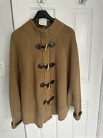 Full view of camel knit toggle cardigan on hanger