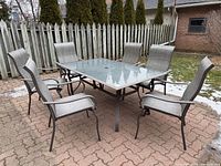 full view of table with six chairs arranged outdoors
