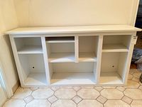 Front view of white console table showing three main sections and shelves