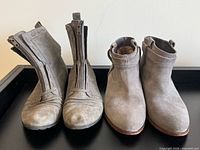 Both pairs of grey suede ankle boots side by side on tray