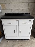 Front view of cabinet showing drawers, doors, countertop and backsplash