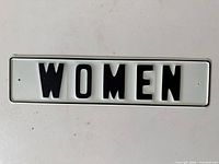 Front of metal sign showing WOMEN text