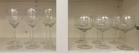 Two rows of six clear wine glasses in cabinet