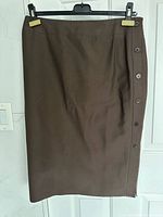 Front view of brown wool skirt hanging on hanger