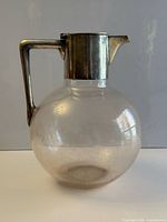 Full view of crystal claret jug showing sterling silver lid, handle and overall form