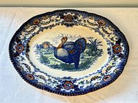 Full view of oval flow blue platter showing turkey scene and border