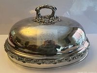 Full view of silver plated meat cloche showing domed form and handle