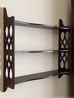 Front view showing full three-tier mahogany wall shelf