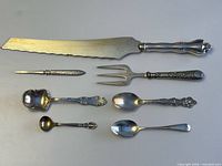 All seven sterling-handled pieces lined up