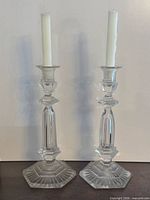 pair of crystal candlesticks with candles present