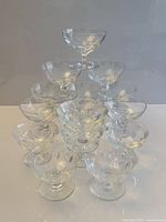 Stacked arrangement of 15 clear crystal thumbprint dessert bowls showing both sizes and stem detail