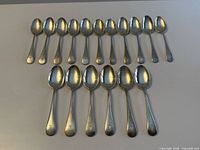 Sixteen Birks sterling teaspoons laid out