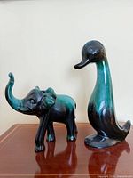 Elephant and duck figurines on wooden surface