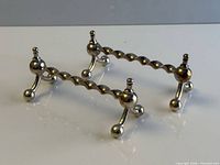 Both silver-plated twisted bar utensil rests on surface