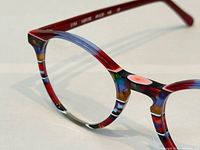 Close-up of right front rim showing multicolour stripe pattern and acetate material