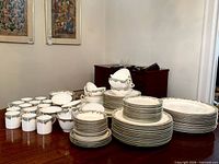 Full set displayed on table showing plates, platters, cups