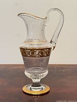 Full view of crystal pitcher showing shape, handle, foot and gold band