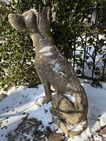 Full left side view of concrete dog statue in snow