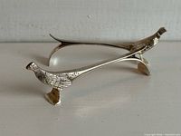 Both silver-plated pheasant knife rests side view