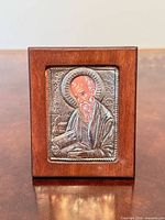 Front view of sterling silver icon on wood backing
