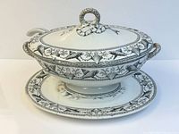 Tureen with lid on platter showing pattern and ladle